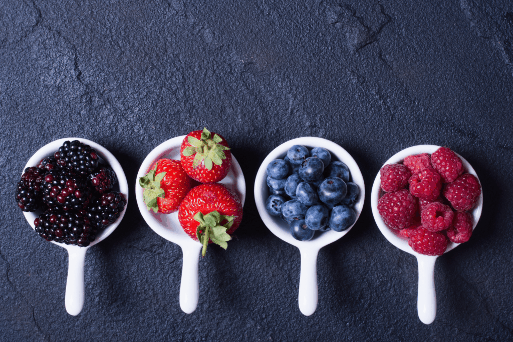 Verschiedene Beeren auf Holzlöffeln – reich an Antioxidantien und wertvollen Pflanzenstoffen.