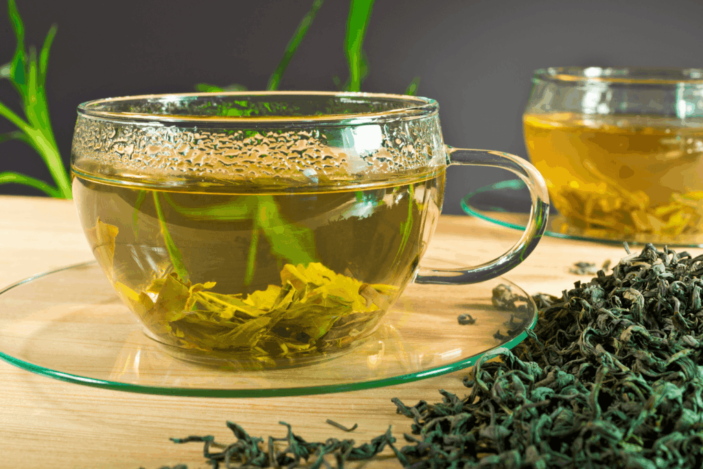 Tasse mit grünem Tee und losem Teeblatt – reich an Antioxidantien und wertvollen Pflanzenstoffen.