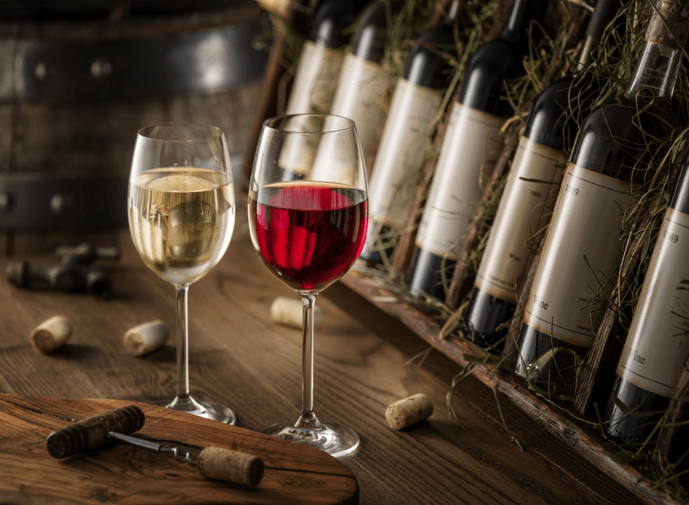 Zwei Gläser Rotwein auf einem Tisch – Alkohol kann Entzündungen fördern und den Körper zusätzlich belasten.
