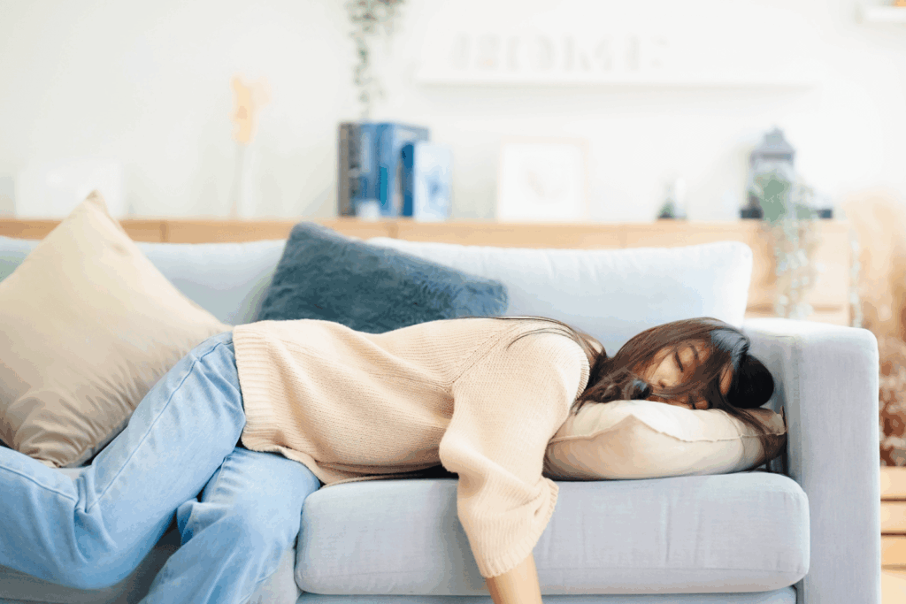 Frau schläft erschöpft auf dem Sofa – ein Symbol für Fatigue und starke Müdigkeit bei Rheuma.